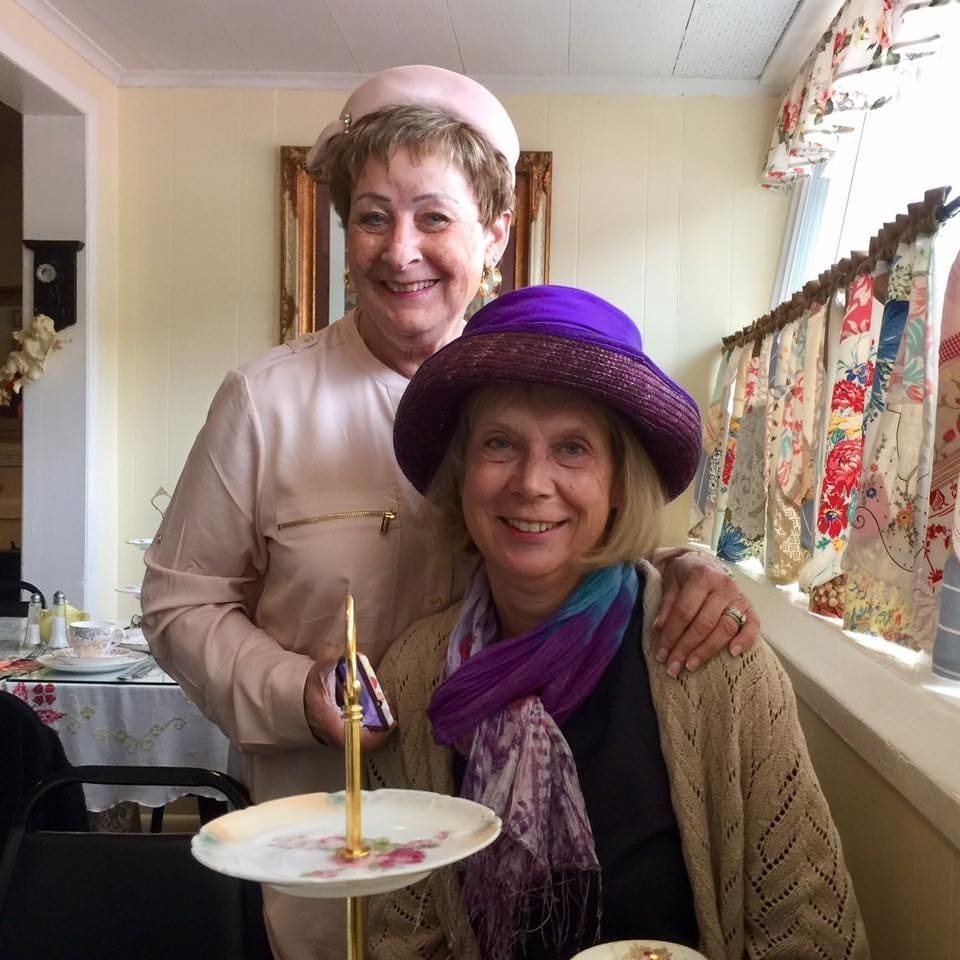 Ann Grossman and Martha Roy sporting some elegant hats