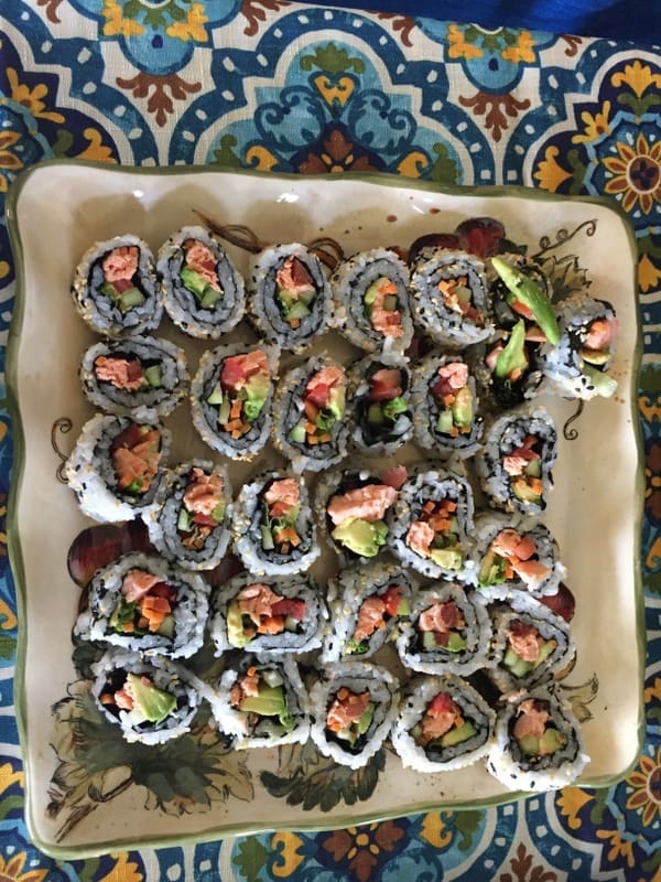 A plate of California roll with poached salmon and avocado