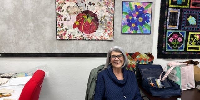 Joyce with a couple of her collage quilts